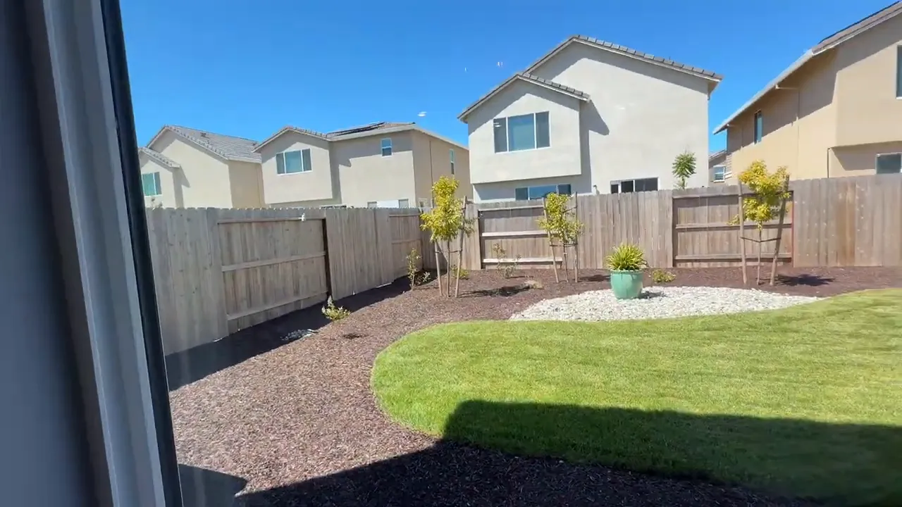 Backyard view with grass and landscaped yard at Arbor Ranch new construction home in Elk Grove