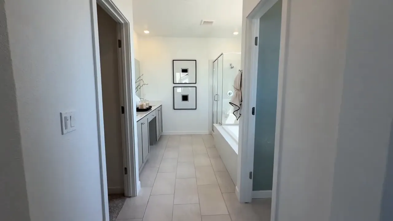 Bright upstairs hallway leading to a private bath with glass shower in Arbor Ranch home