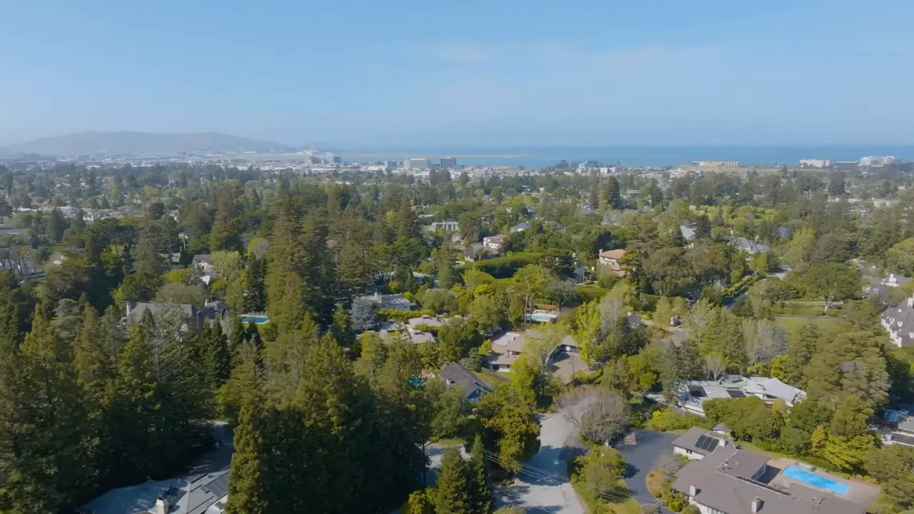 Aerial view of residential neighborhoods on the Peninsula with trees and distant ocean