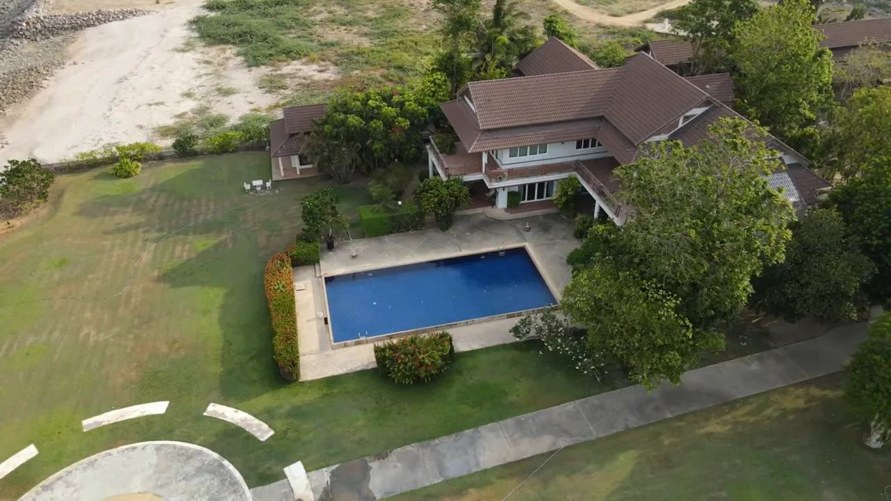 Aerial view of a large house with backyard pool and surrounding yard