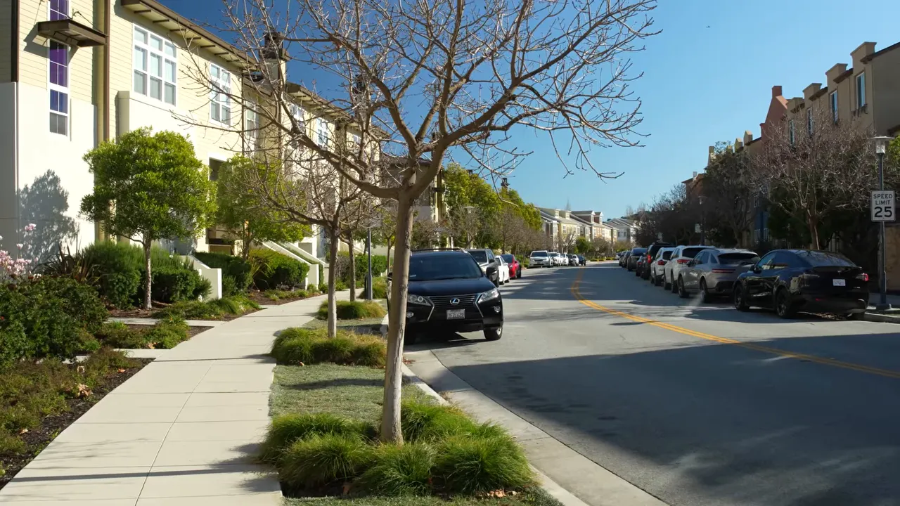Residential boulevard with sidewalks, trees, and parked cars in San Mateo