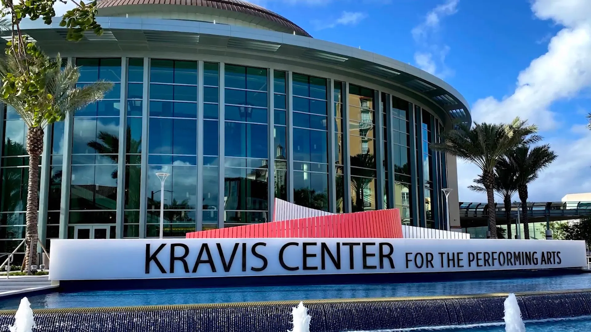 Front view of the Kravis Center for the Performing Arts with fountain, sign and palm trees