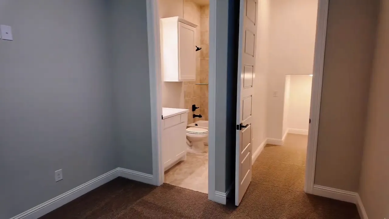 Hallway view leading to a guest bedroom and full bath in a new construction home near Dallas, TX