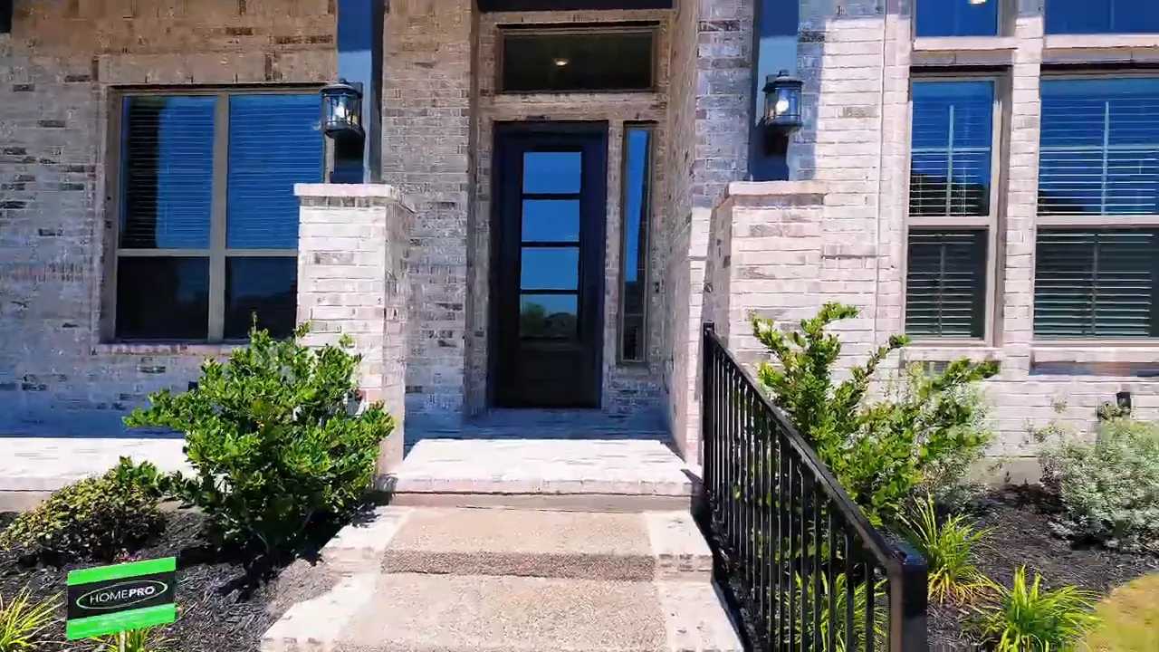 Front entry and covered porch with brick and stone exterior of a new construction home near Dallas TX