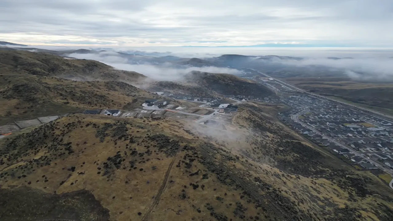 Aerial view of foothills above a layer of winter inversion clouds