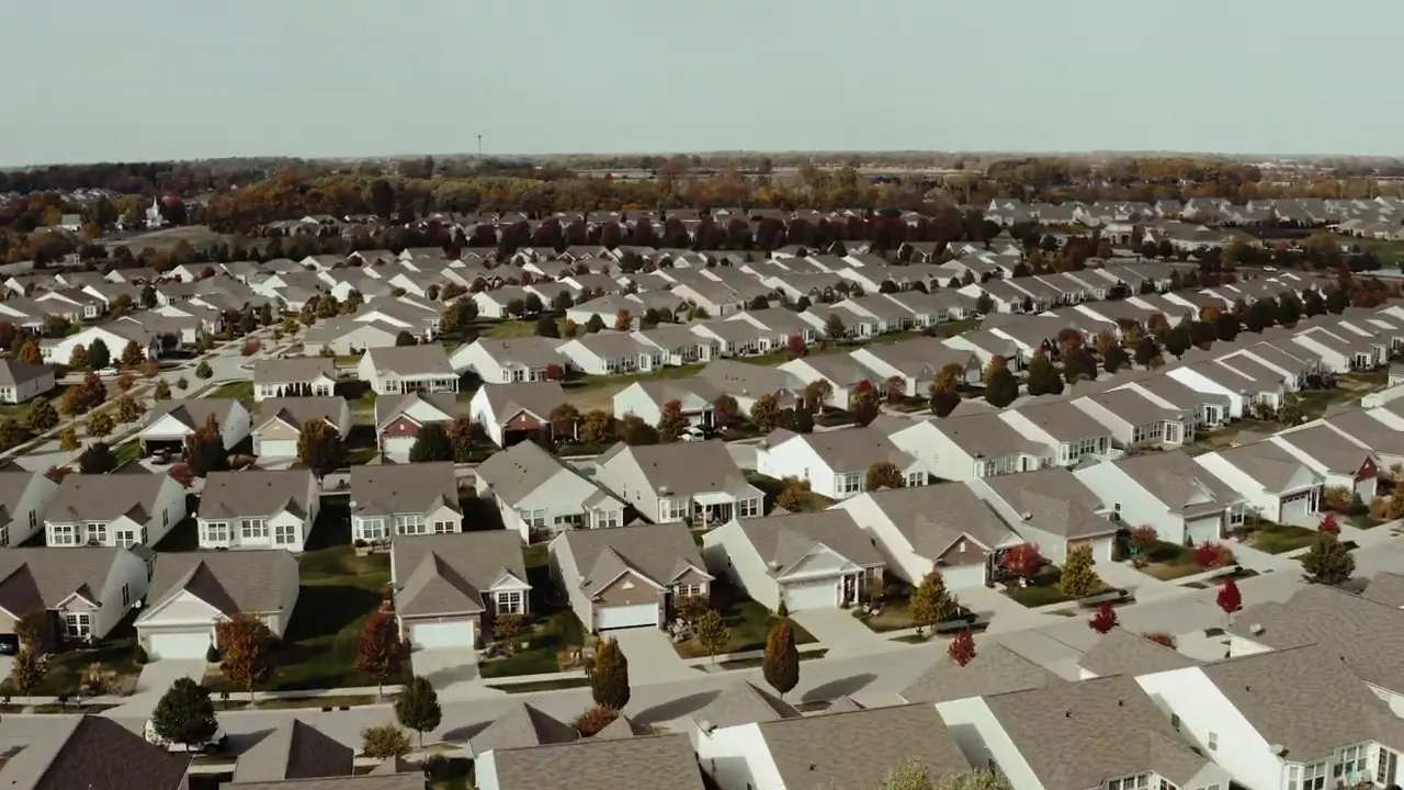 Close aerial view of rows of new single‑family homes in a suburban development