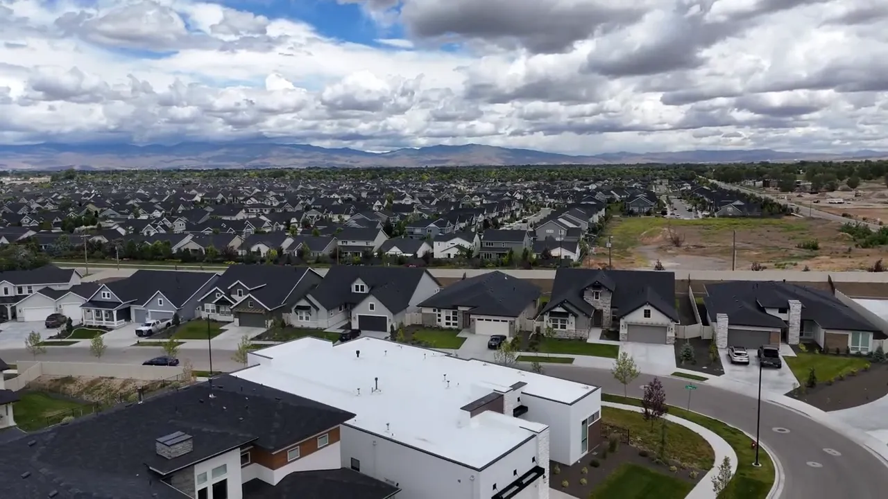 Aerial shot of homes and streets showing neighborhood layout and nearby open land