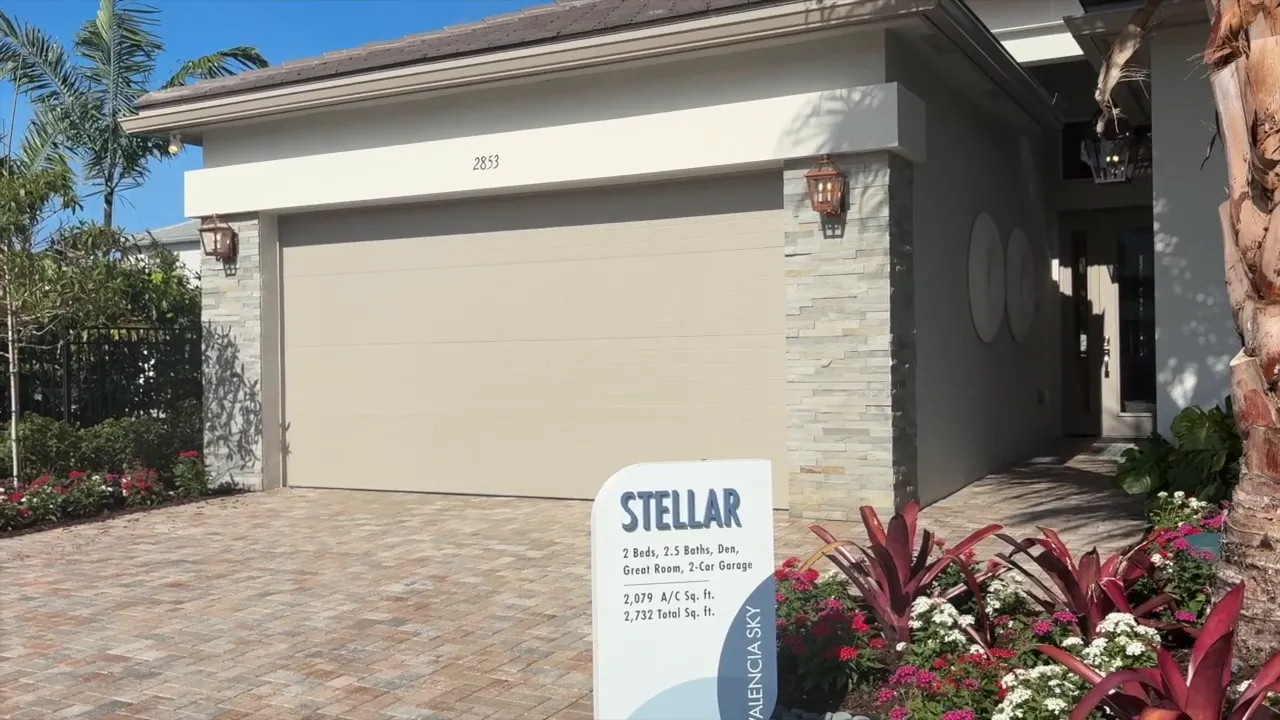 Stellar model exterior at Valencia Sky Naples FL with model sign and landscaped front