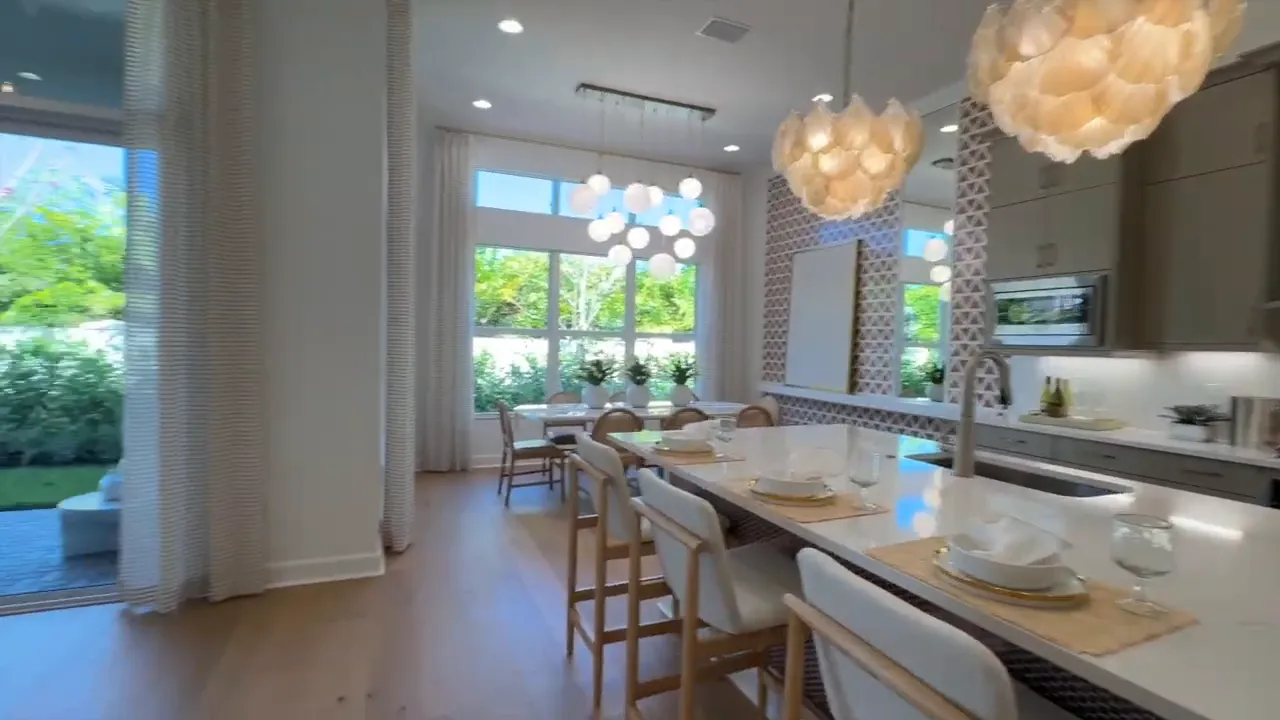 Stellar model dining and kitchen view showing open layout and natural light from rear windows in Valencia Sky Naples FL