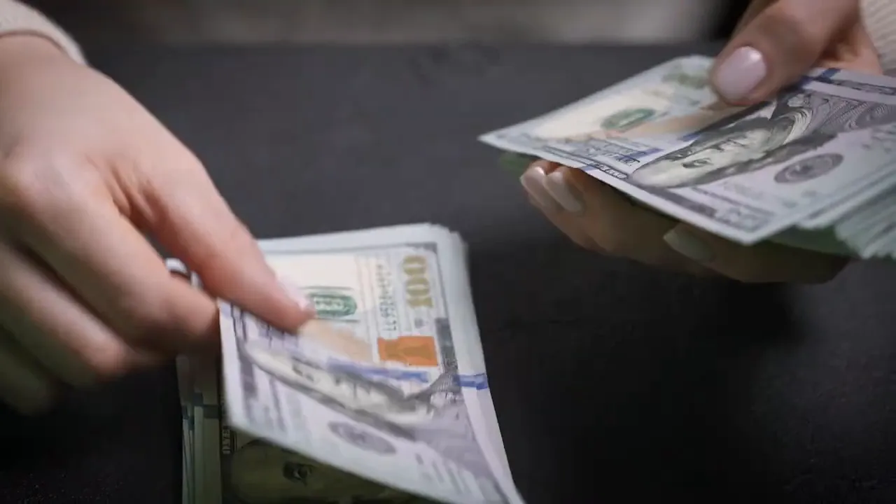 Hands holding and counting U.S. cash representing closing costs and money to close