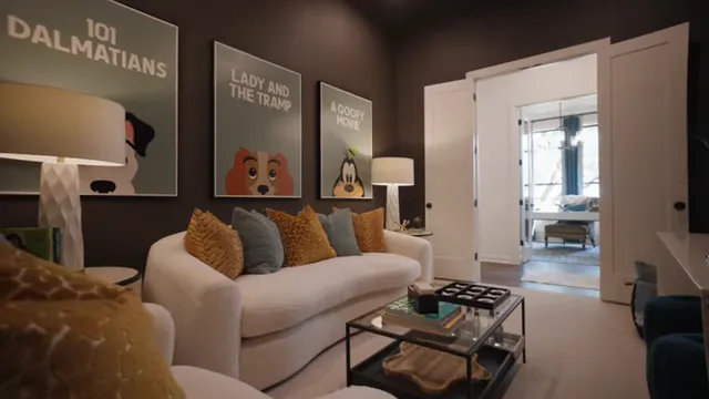 Dark media room with white sofas television and framed movie posters