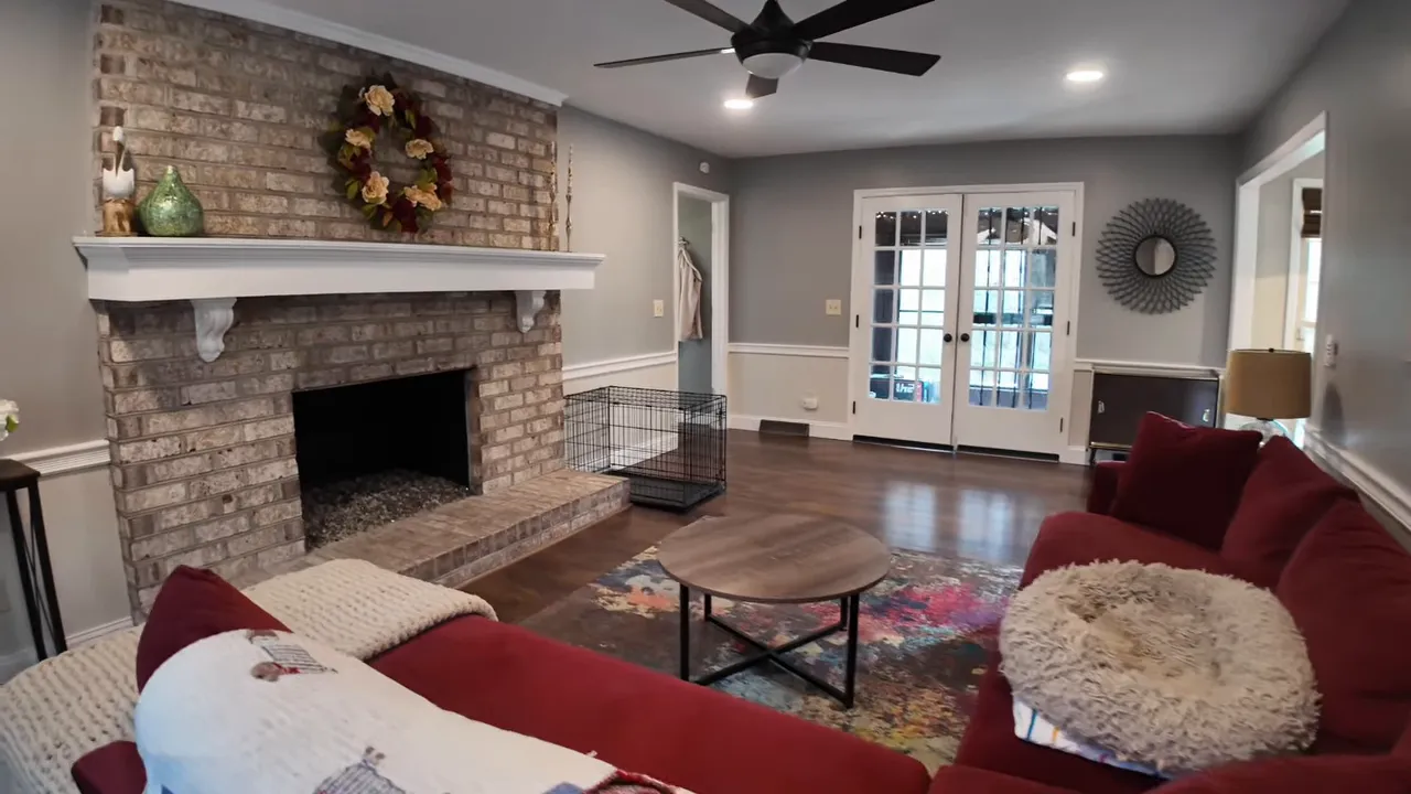 Stone fireplace living room with seating and dark hardwood floors