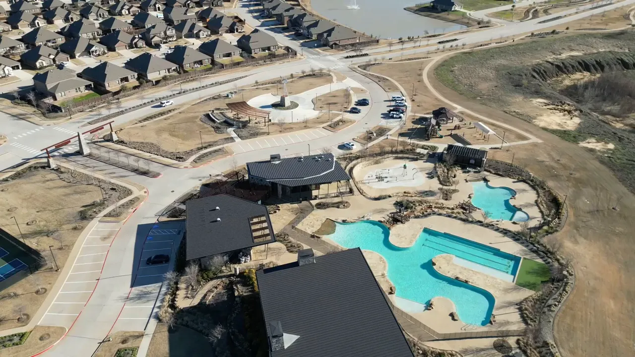 Aerial view of community buildings and multiple turquoise swimming pools