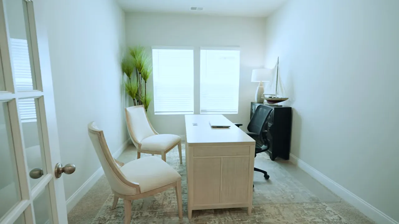 Bright flex room with desk, chairs, and windows showing potential office or hobby space