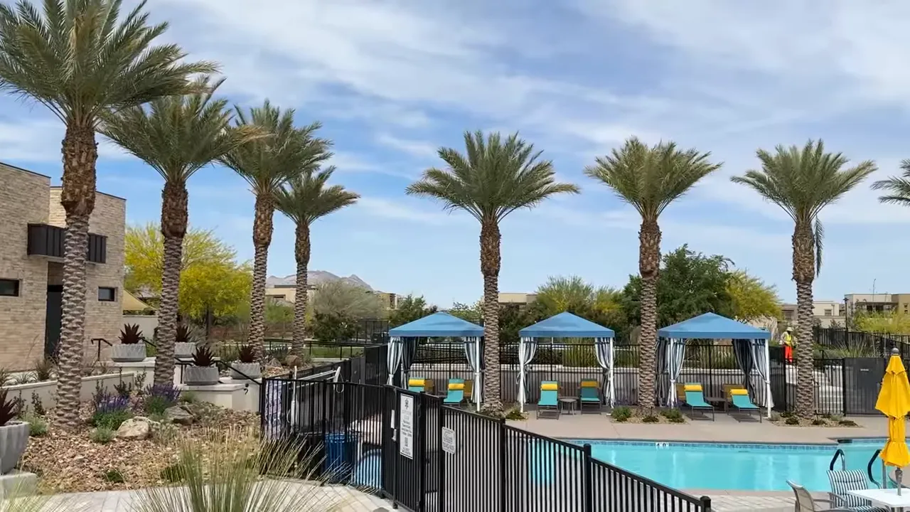 Resort pool with palm trees and blue cabanas at Outlook Club