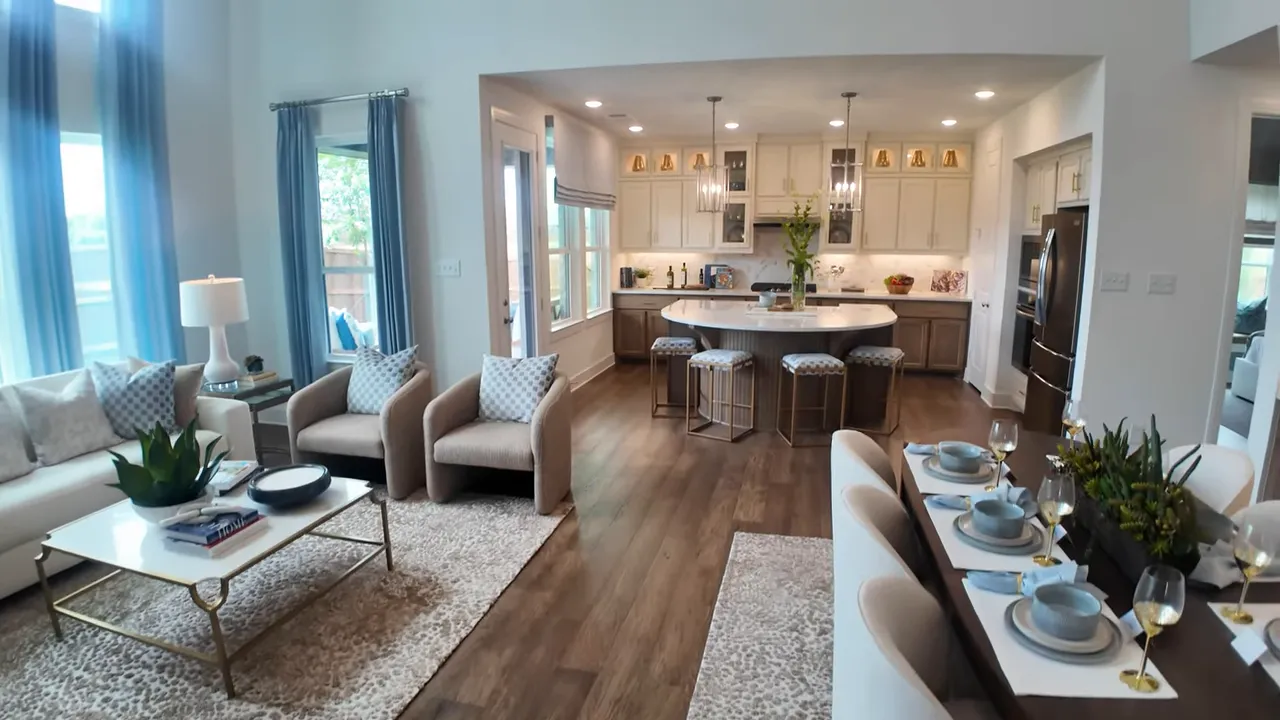 Open living area with dining table, kitchen island, seating area and tall ceilings
