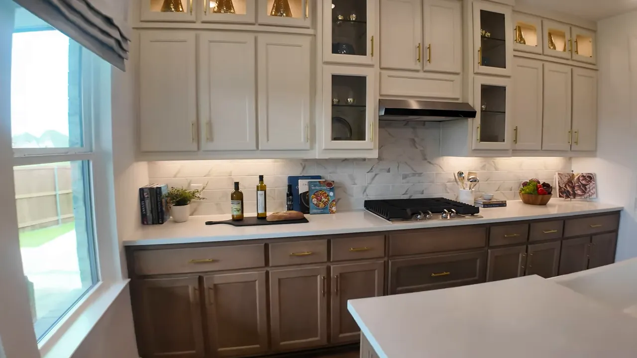 Kitchen wall with stacked upper cabinets, cooktop, vent hood and light countertops