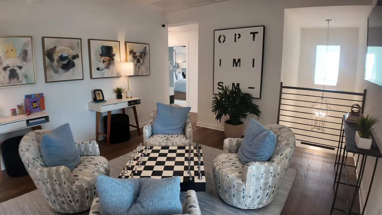 Upstairs game room with four chairs, checkerboard coffee table and wall art