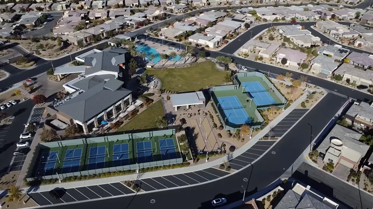 Aerial view of community clubhouse pools and pickleball courts