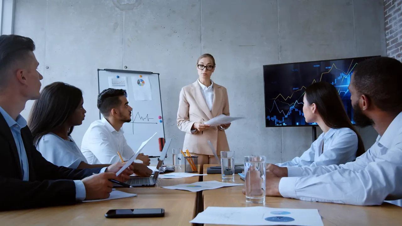 Business presenter standing in front of a screen during a meeting