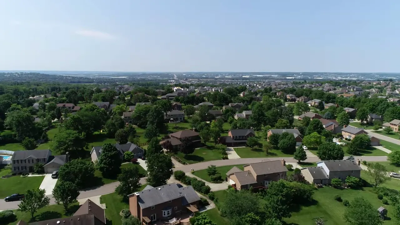 Aerial view of a large suburban neighborhood with homes and trees