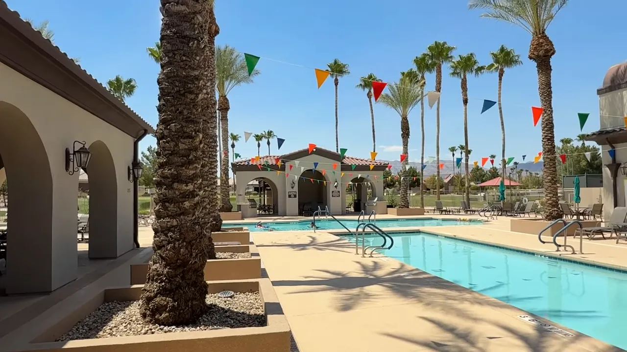 Resort style pool surrounded by palm trees and Spanish architecture