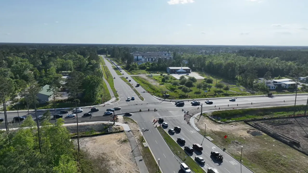 Aerial view of busy highway intersection with long lines of vehicles