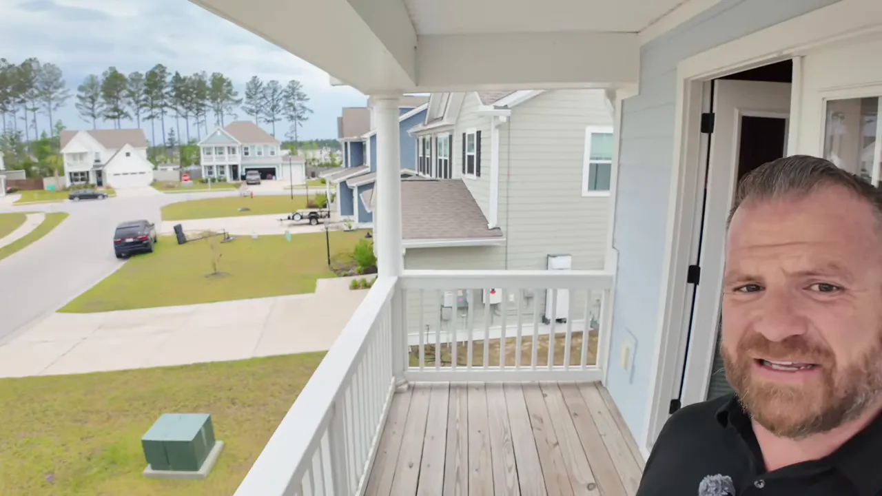 covered second floor front balcony with white railing and neighborhood view