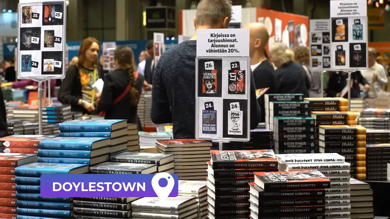 Stacks of books on display in a bookstore or market with a 'DOYLESTOWN' location label overlay