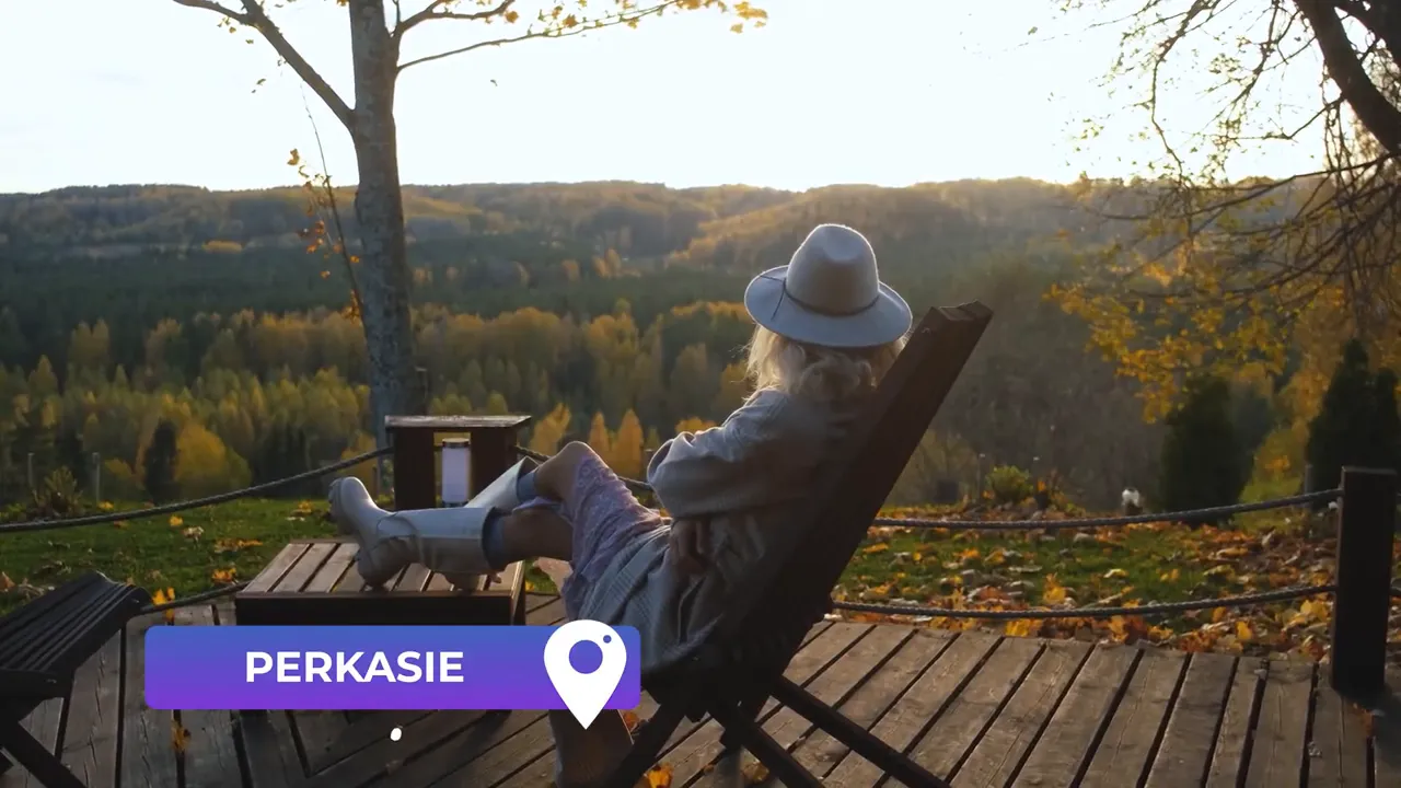 Person sitting on a wooden deck overlooking rolling, forested hills in autumn with a 'Perkasie' label overlay