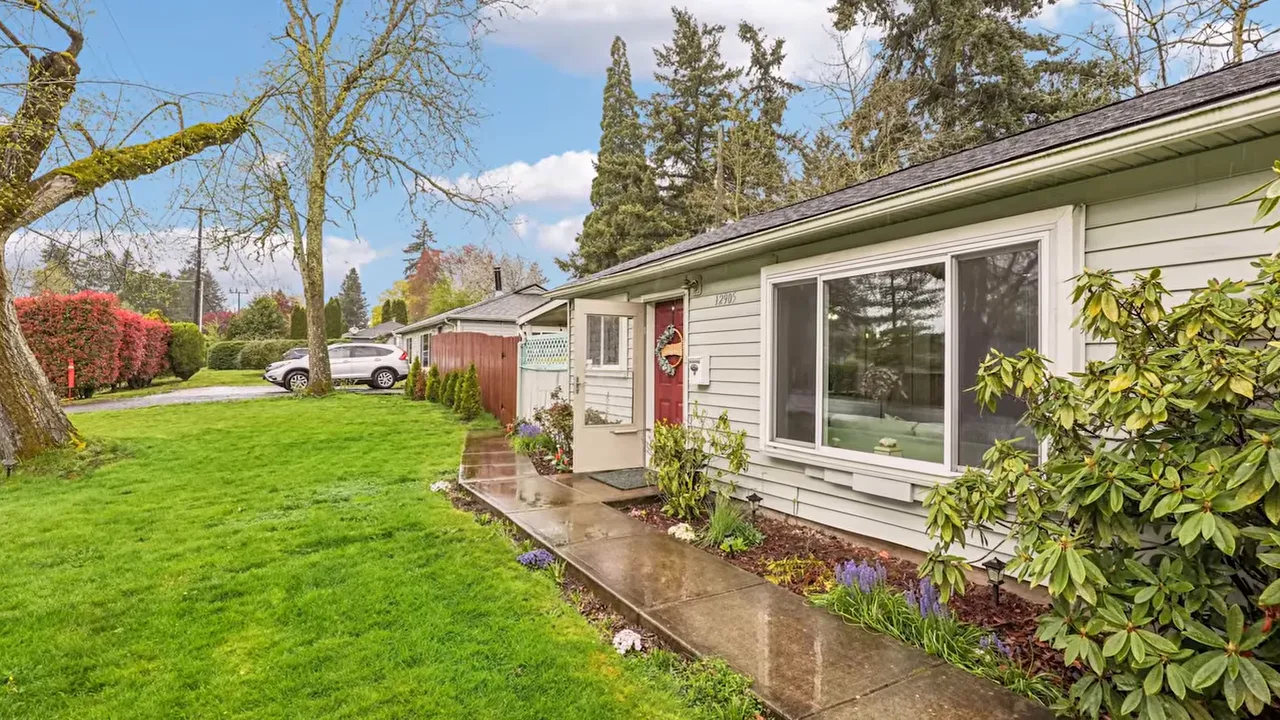 Front exterior of a single-family home with porch, windows, and landscaped yard