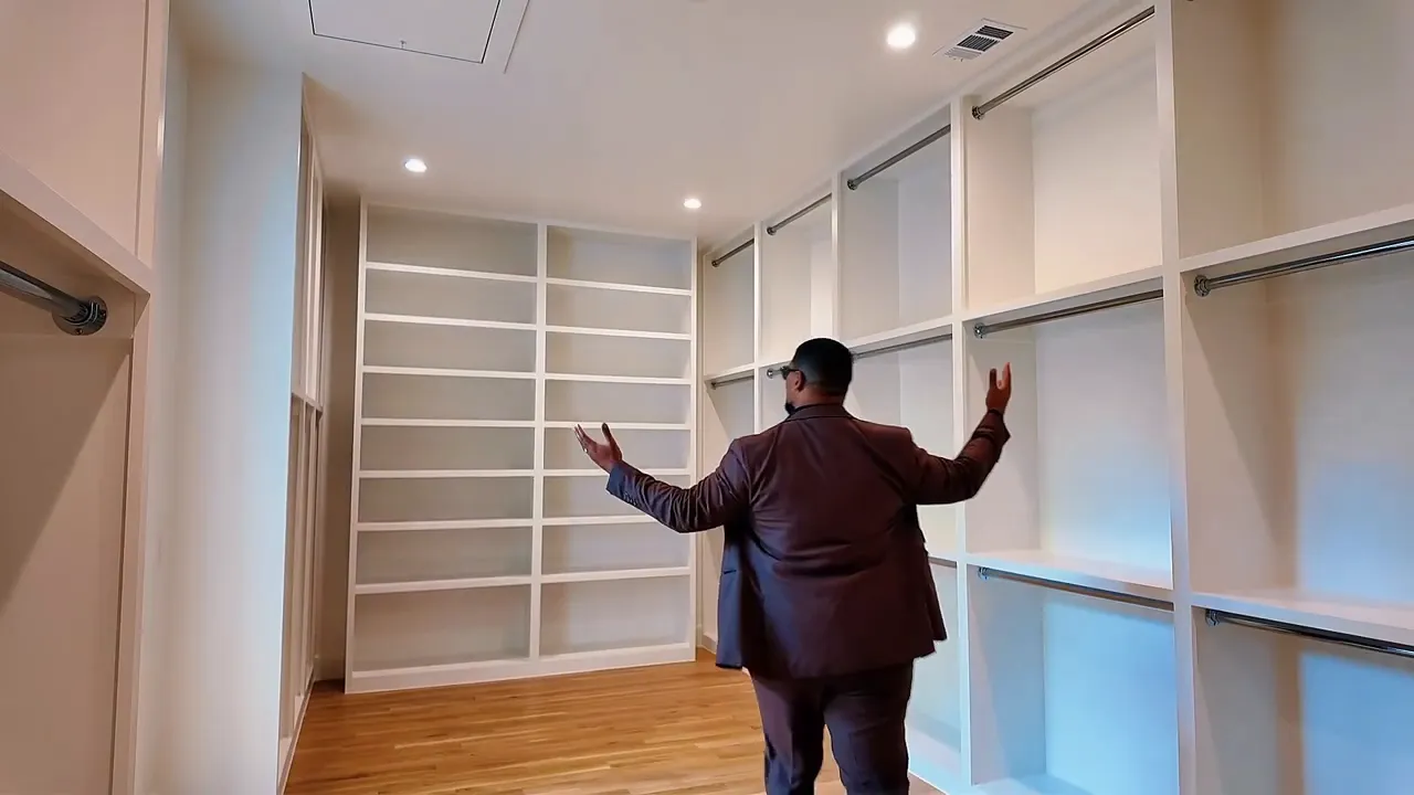 Luxury primary closet with custom built-in shelving and organized storage drawers