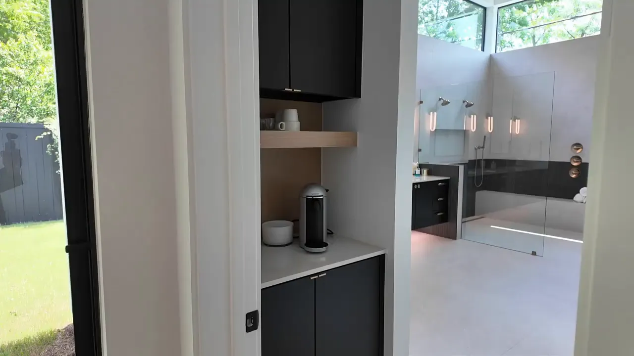 Primary suite built-in coffee station area with dark cabinets and countertop near the bathroom