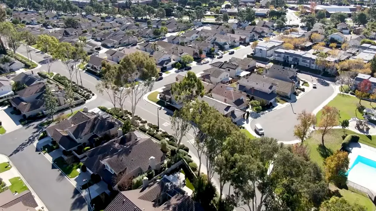 Aerial view of an Orange County neighborhood with homes, streets, and a pool