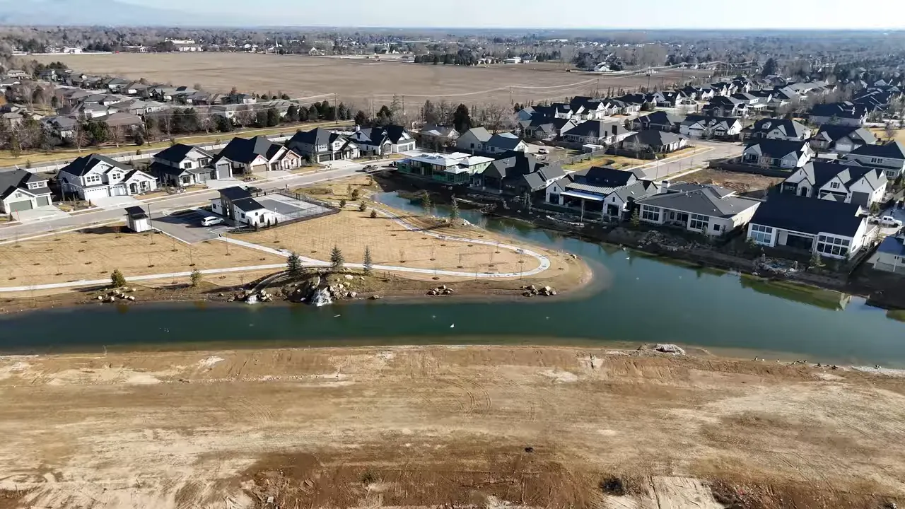 Aerial view of new homes surrounding a curved waterway in a developing neighborhood