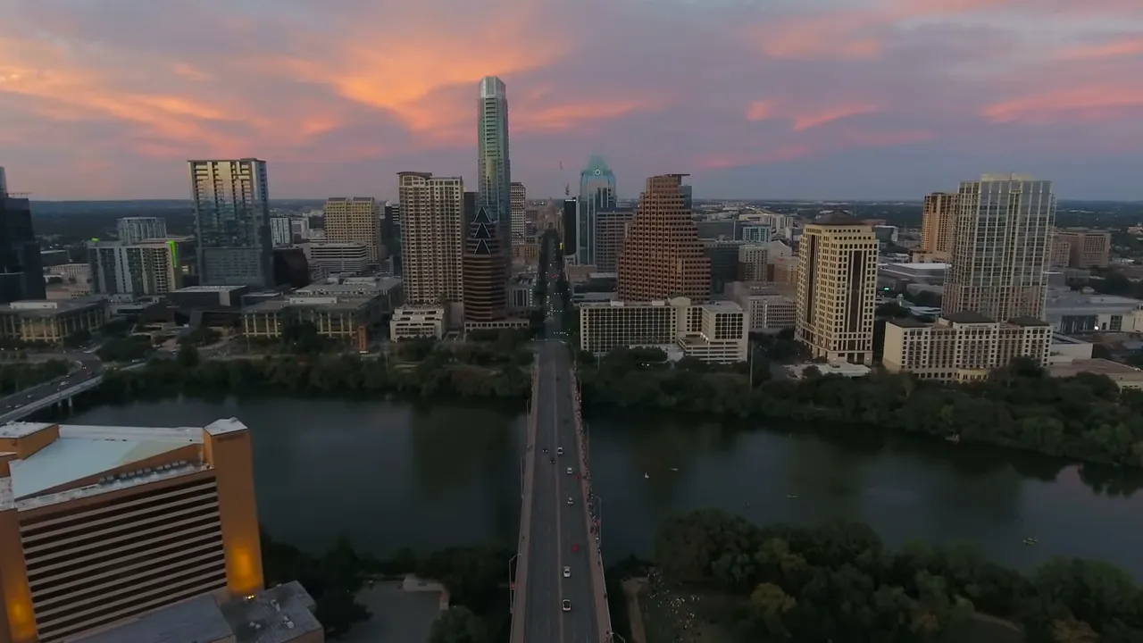 Sunset aerial view of Austin downtown with the river and bridge leading into the city.
