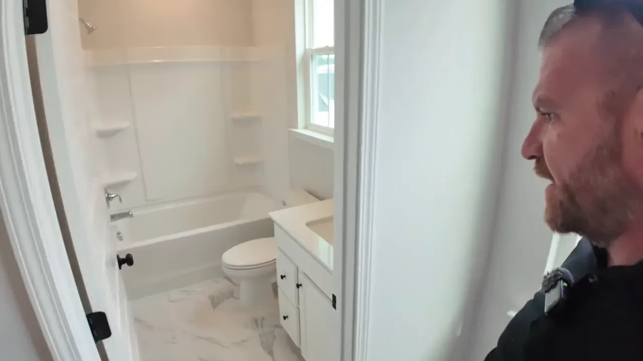 Close-up of an upstairs bathroom with a white vanity, toilet, and bathtub in a new construction home