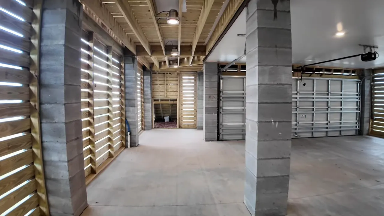 Large under-home garage-level utility space with multiple vehicle storage and concrete flooring in Summers Corner SC