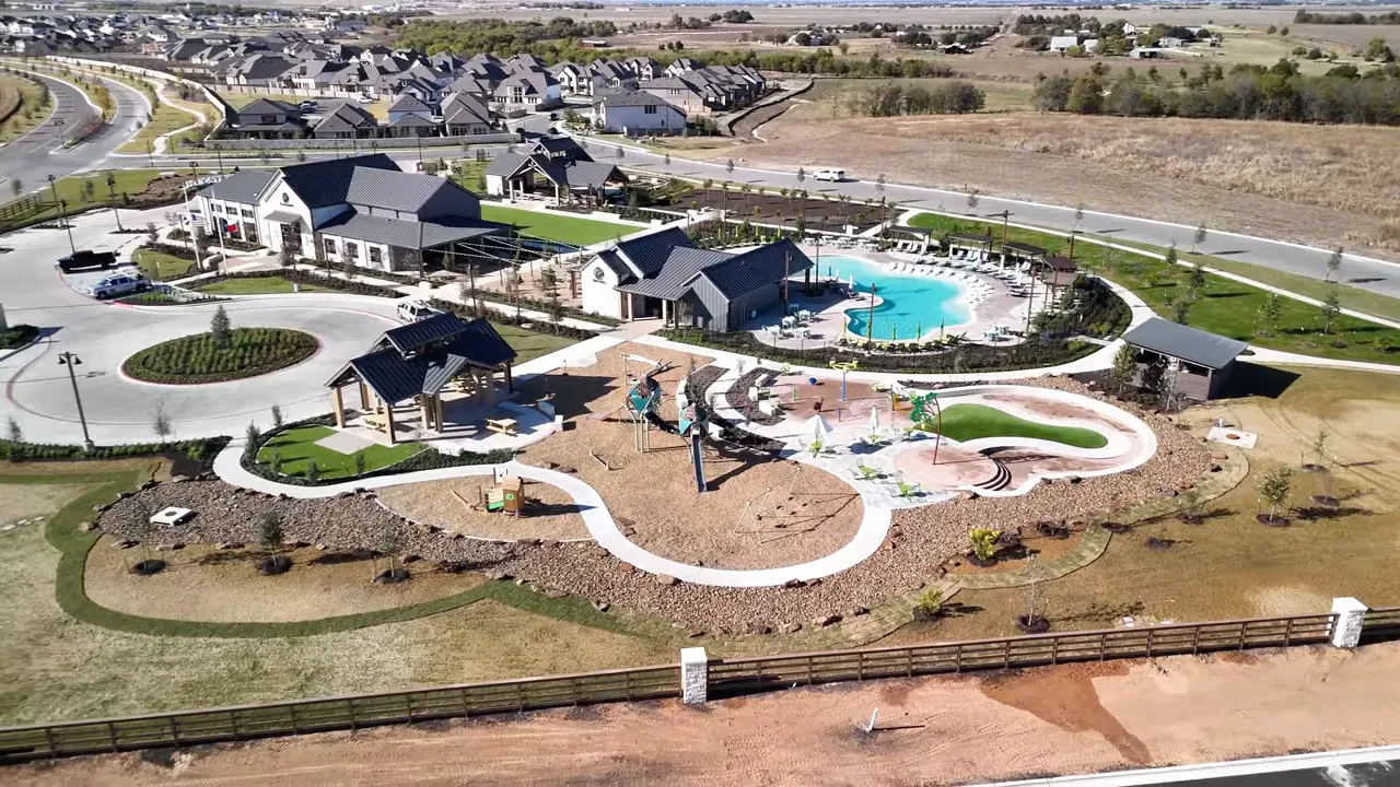 Aerial view of Flora in Hutto amenity center with clubhouse, large resort-style pool and children's splash area.