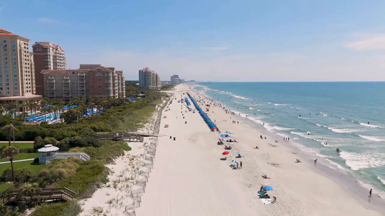 Wide aerial view of North Myrtle Beach showing sandy beach, ocean and beachfront buildings