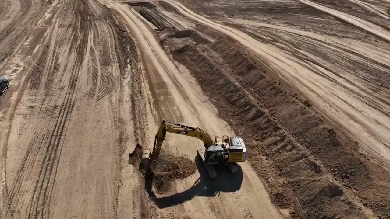 Construction equipment grading and excavating land at Aurora Highlands during ongoing development