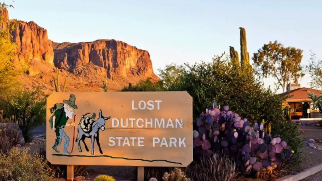 Lost Dutchman State Park entrance sign with Superstition Mountains behind it