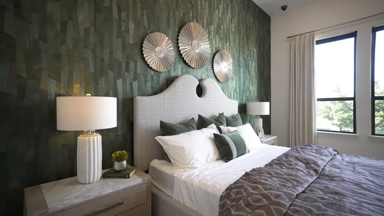 Large primary bedroom with bed windows accent wall and patterned rug