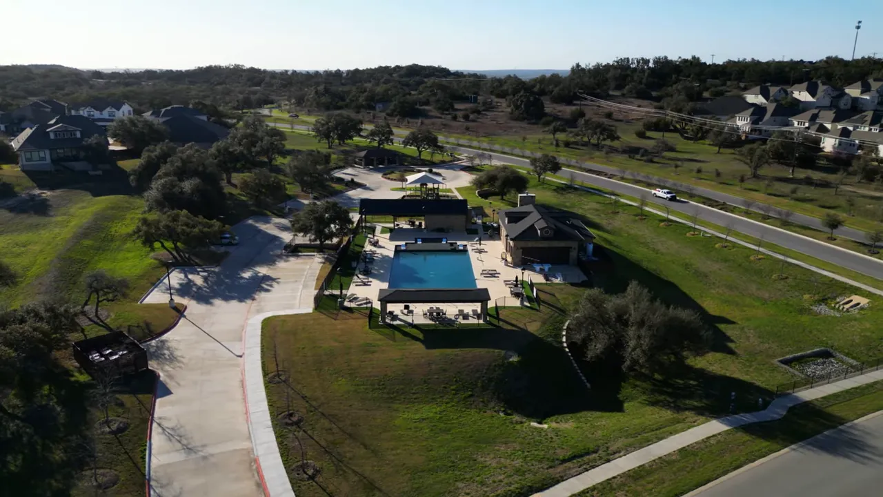 Aerial view of neighborhood pool clubhouse and surrounding homes