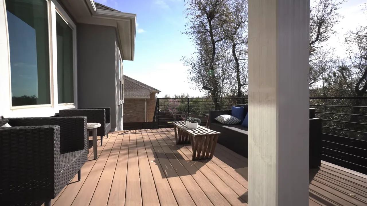 Wood deck patio with outdoor seating beside the rear of the house