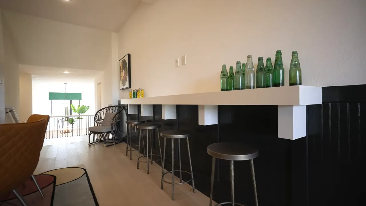 Upstairs game room with long bar counter stools and beverage area
