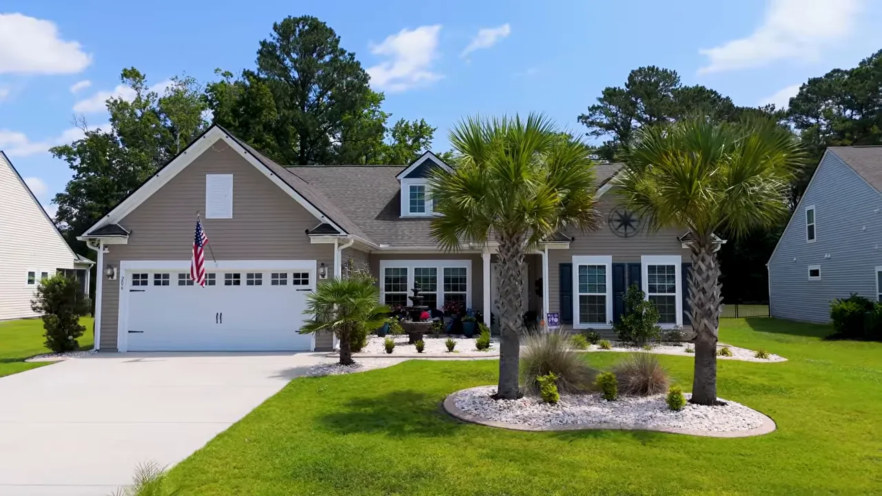 Front exterior of the house with palm trees driveway and landscaped yard