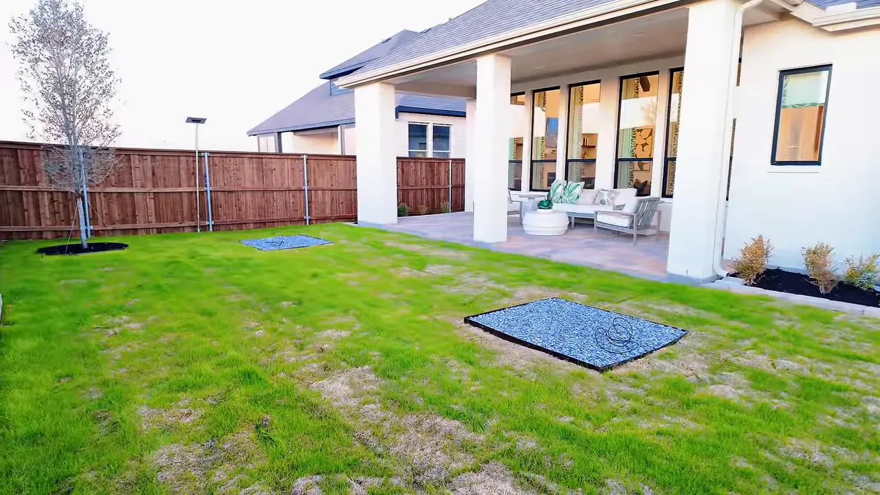 Backyard with large lawn covered patio outdoor seating and wood privacy fence
