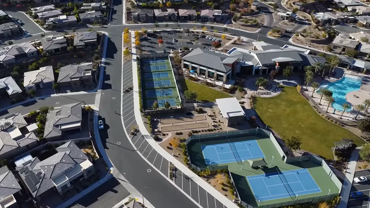 Aerial view of community clubhouse pools and pickleball courts