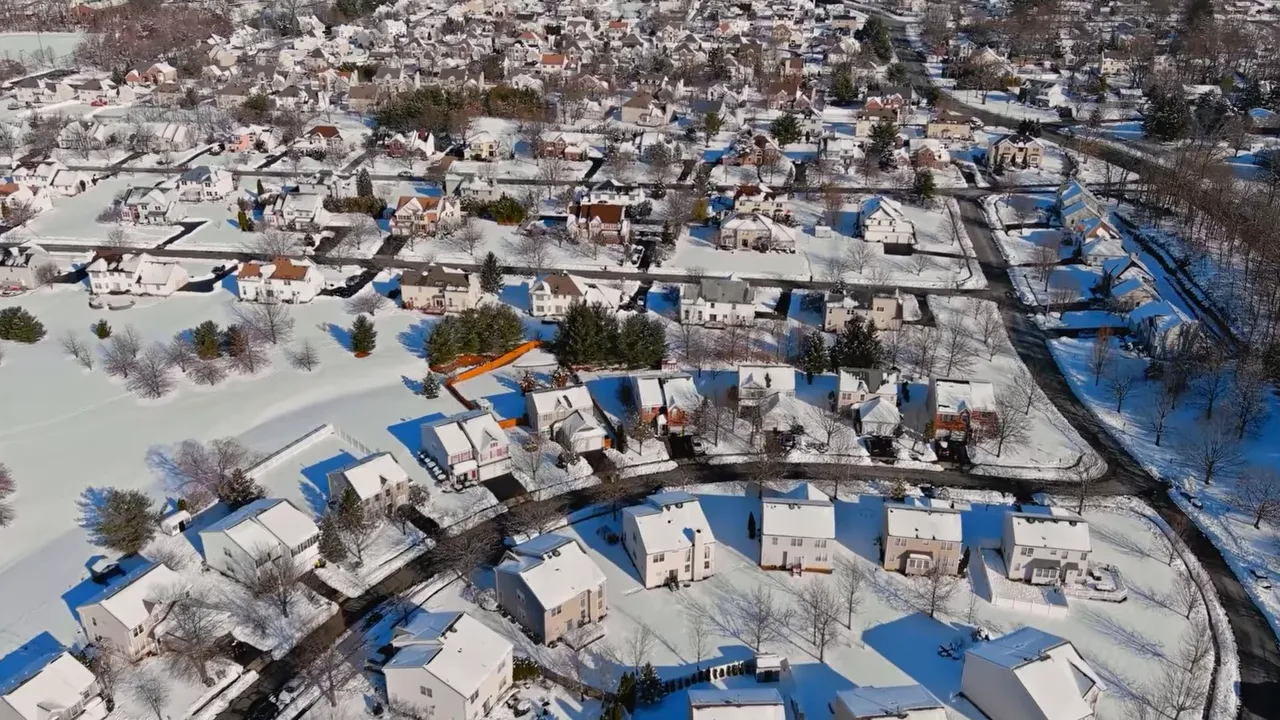 Aerial view of snow covered homes and neighborhood streets